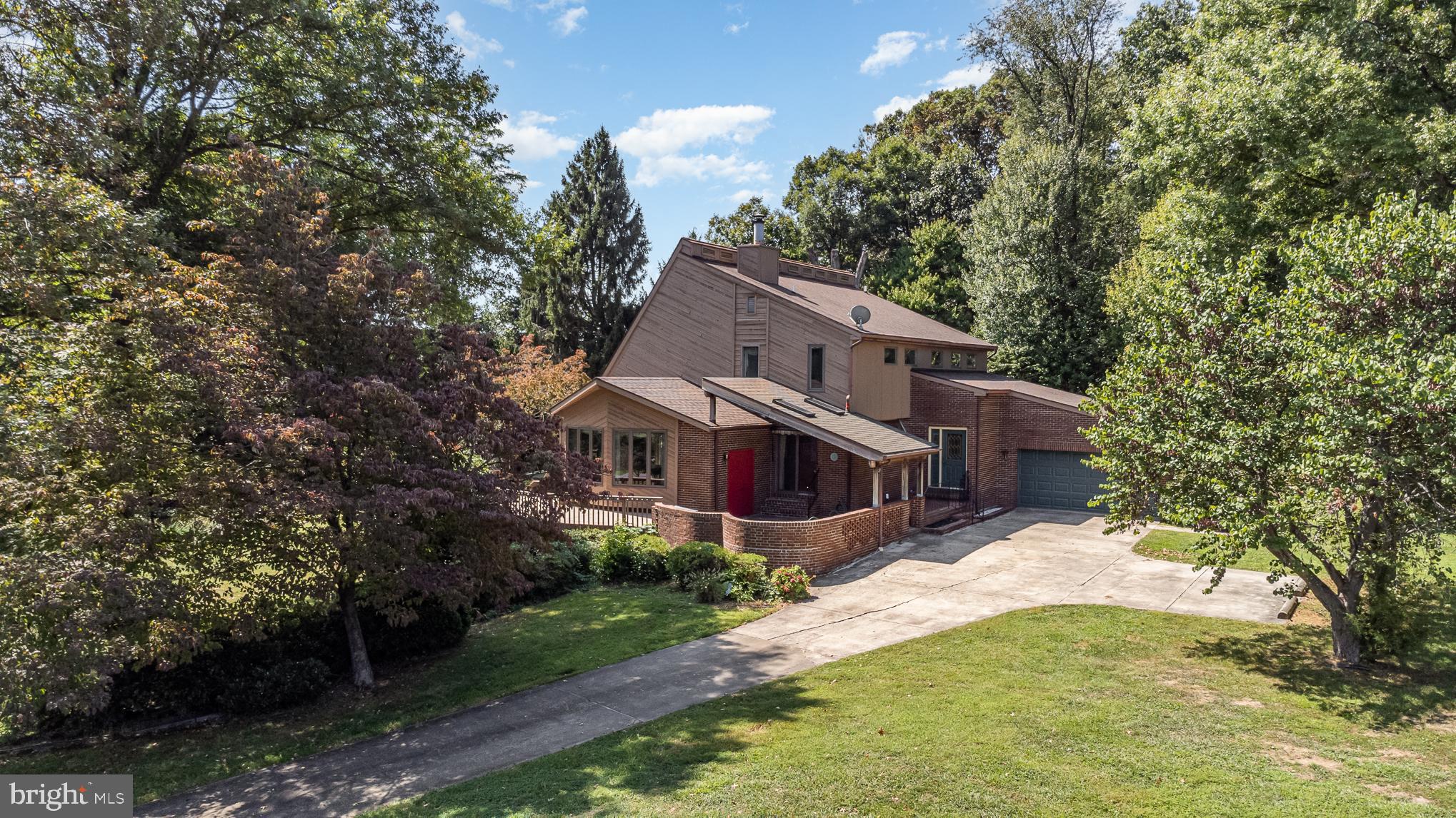 a front view of house with yard and trees in the background