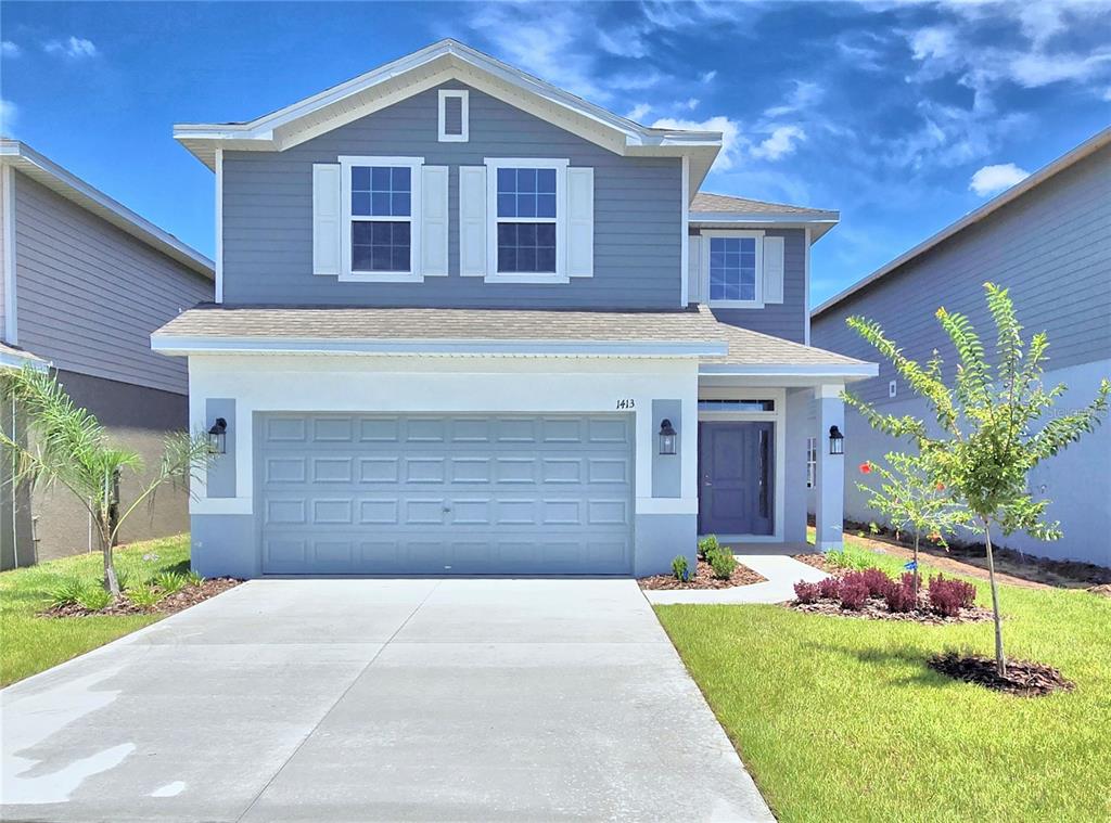 a front view of a house with a yard and garage