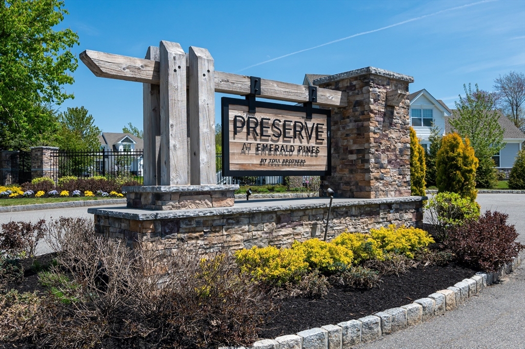 a view of a sign board with buildings in the background