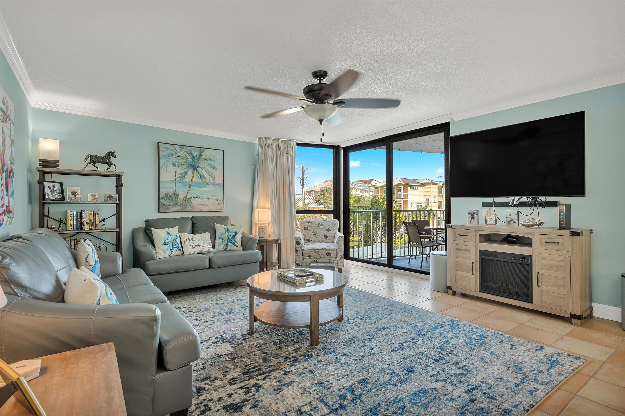 a living room with furniture a flat screen tv and a floor to ceiling window