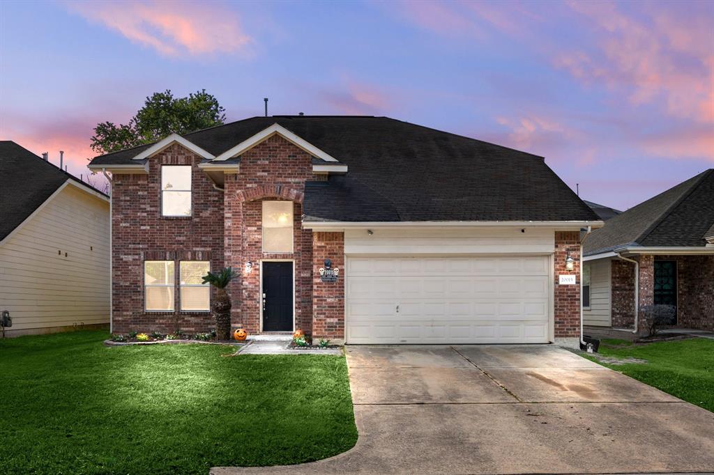 a front view of a house with a yard and garage