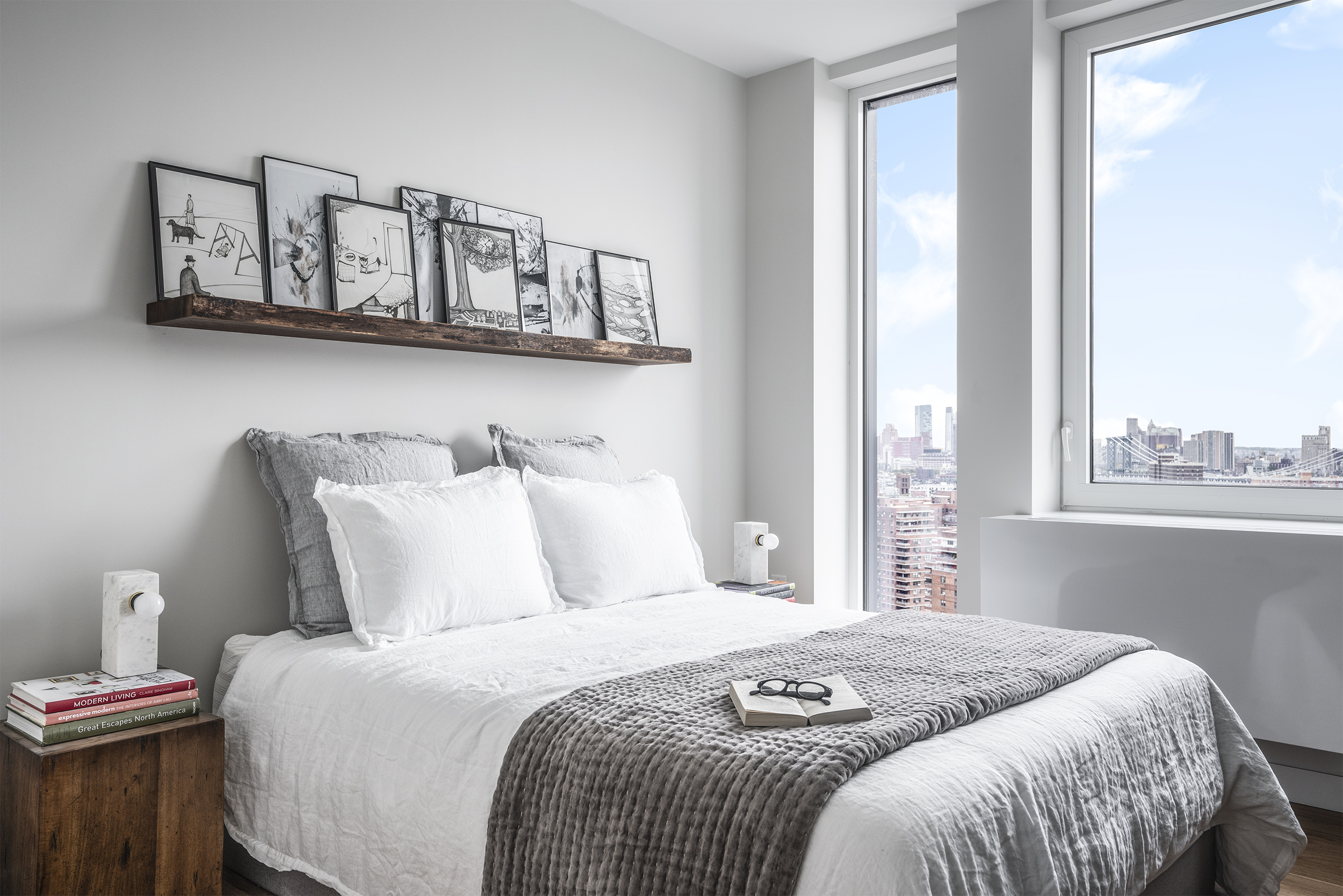 a bedroom with a bed a window and painting on the wall