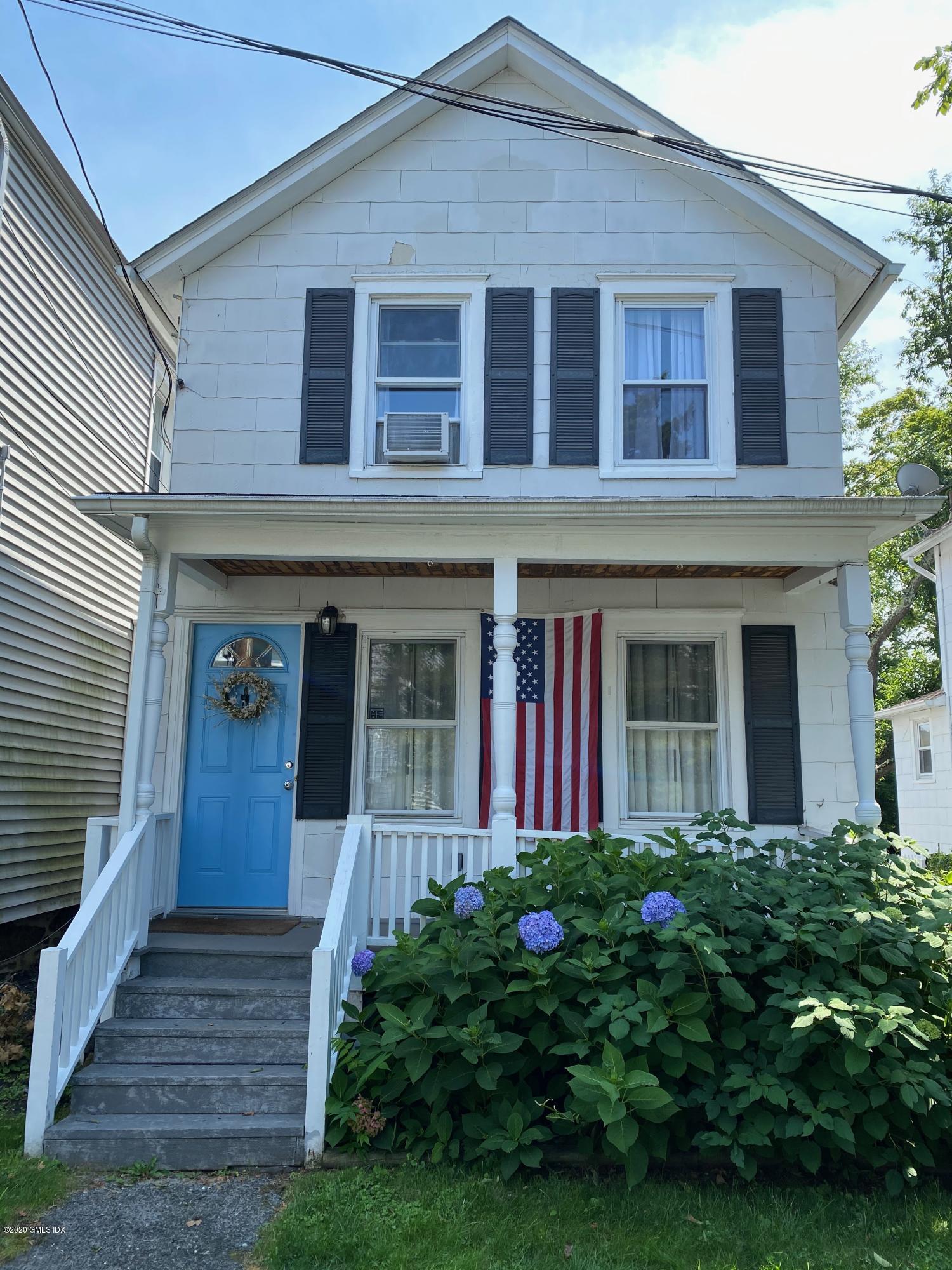 a view of a house with potted plants and a yard