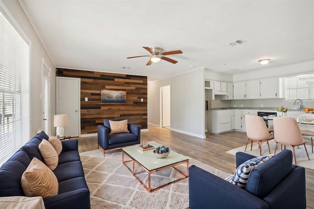 a living room with furniture kitchen view and a large window