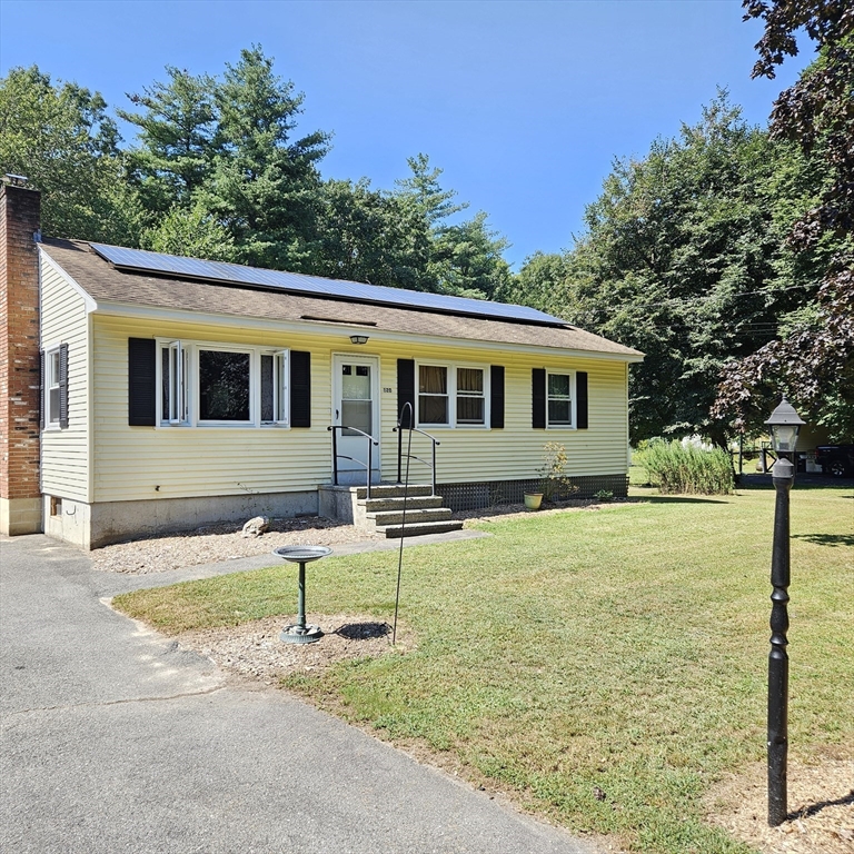 a view of a house with backyard and trees