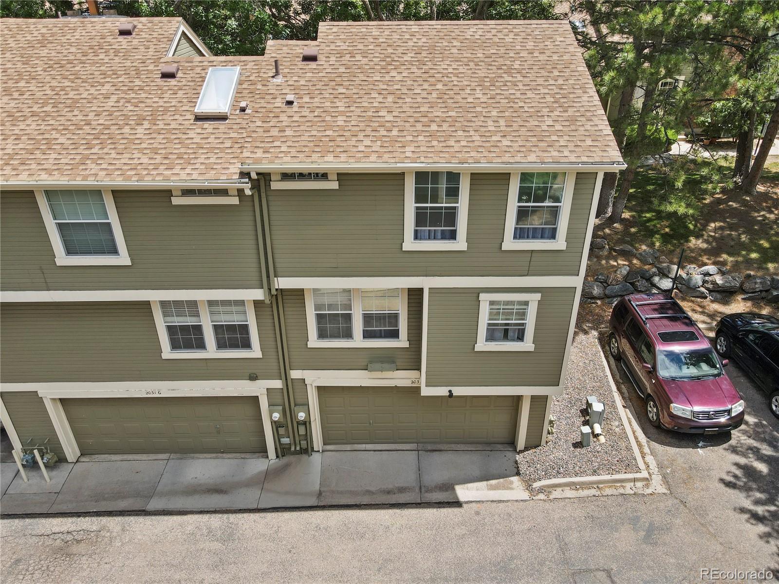 a aerial view of a house with a garden and parking space