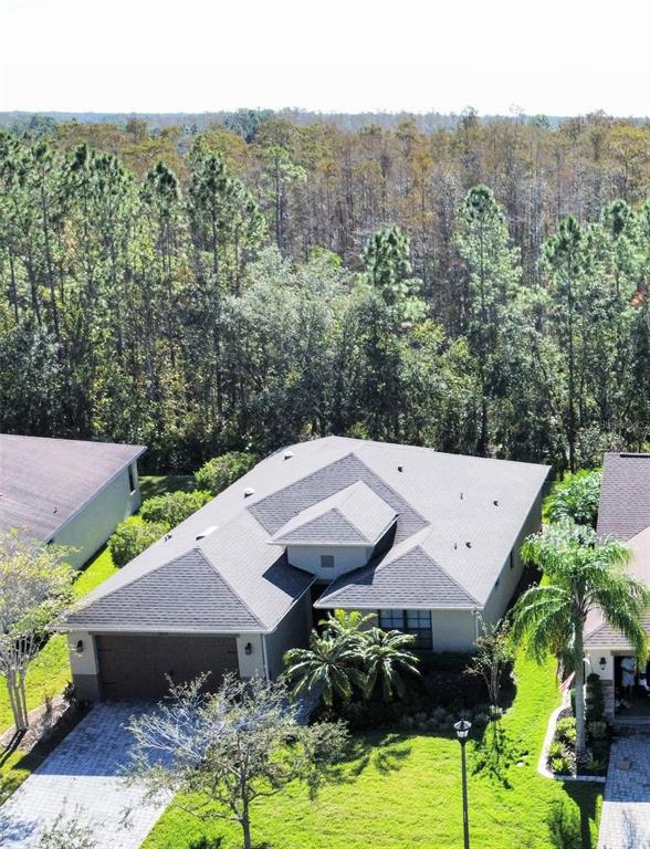 an aerial view of a house with swimming pool and a yard