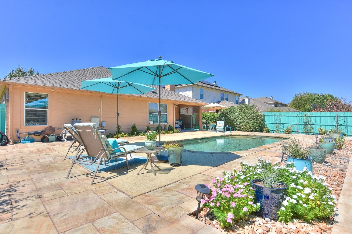 a view of a patio with a table and chairs under an umbrella