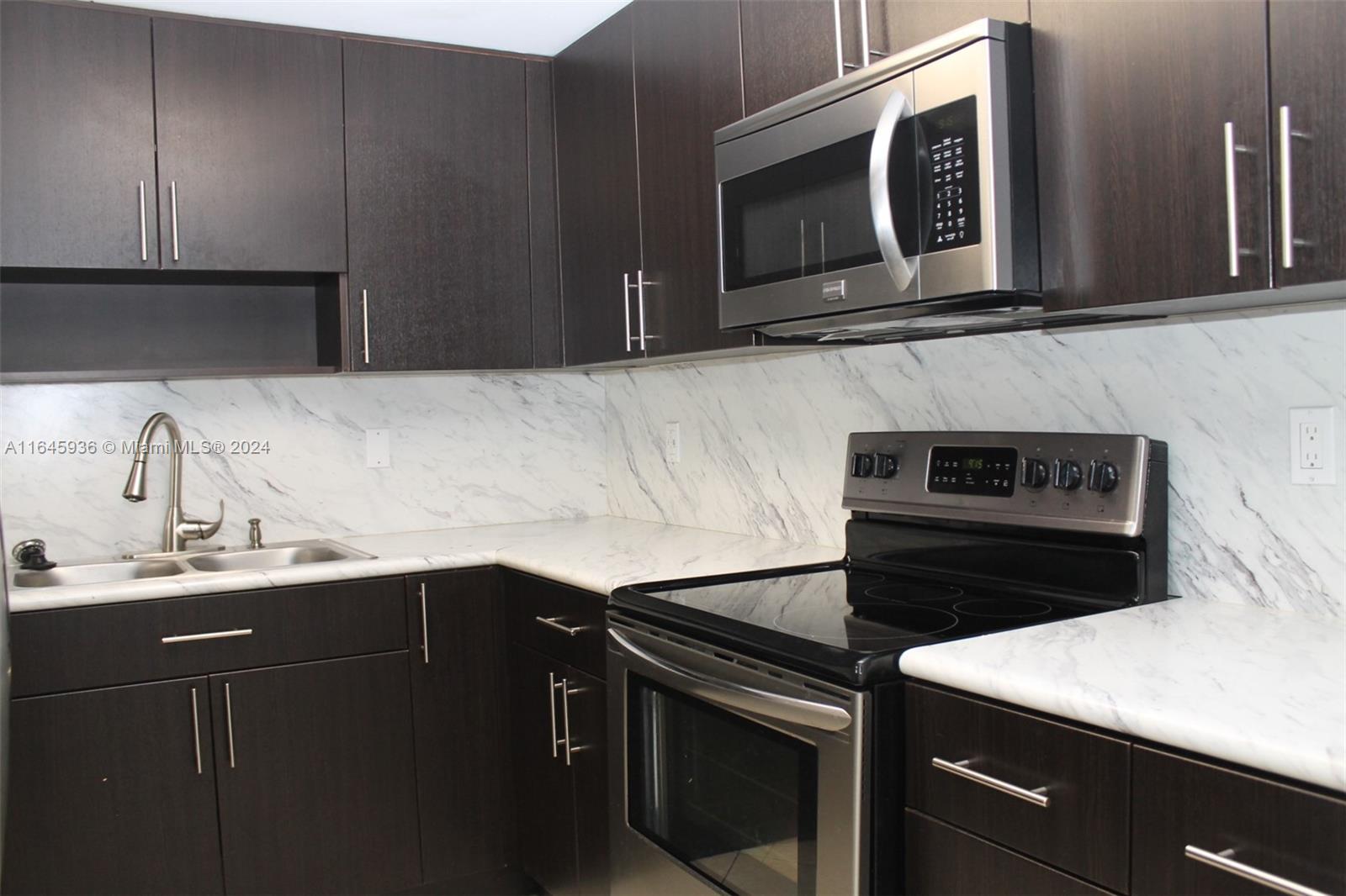 a kitchen with a sink stove and microwave