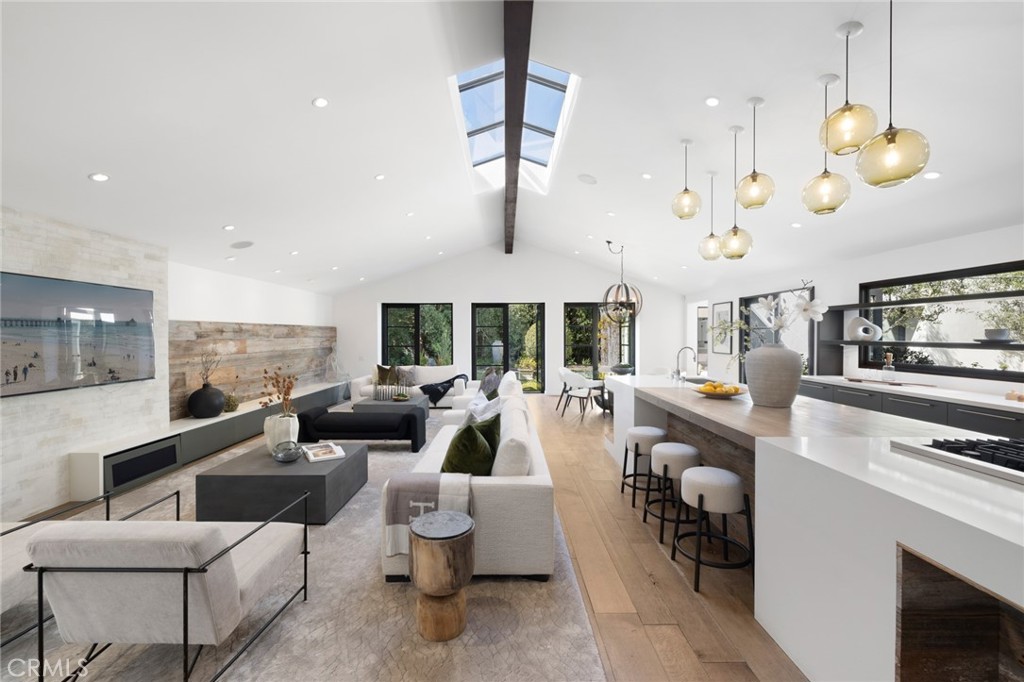 a living room with furniture kitchen view and a large window