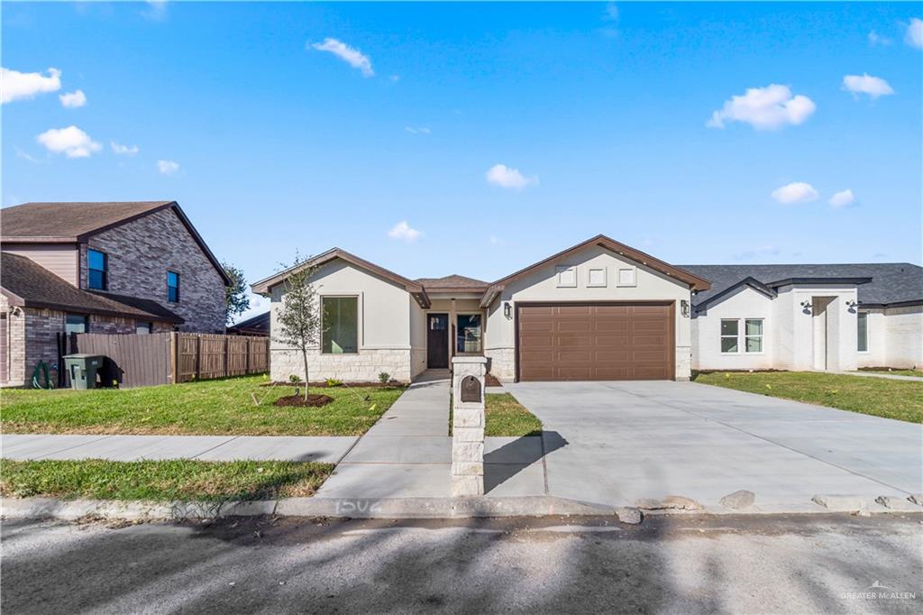 View of front of house featuring a front yard and a garage