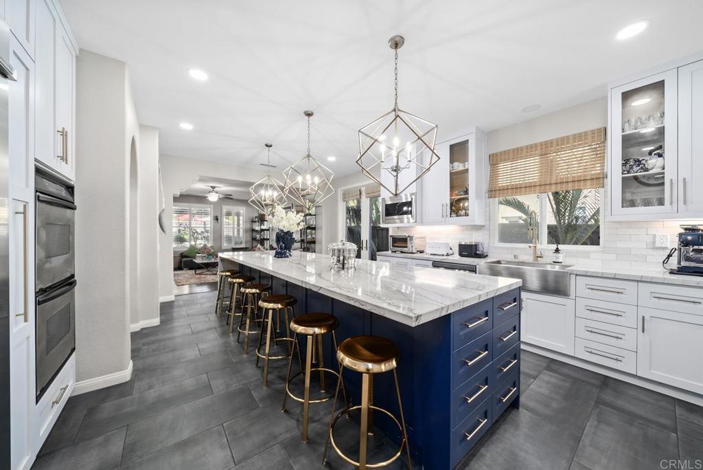 a kitchen with kitchen island granite countertop a sink a counter top space appliances and cabinets