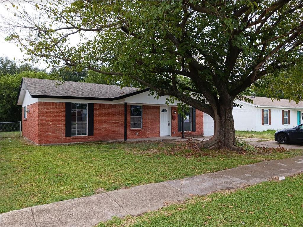 a front view of a house with a garden and trees