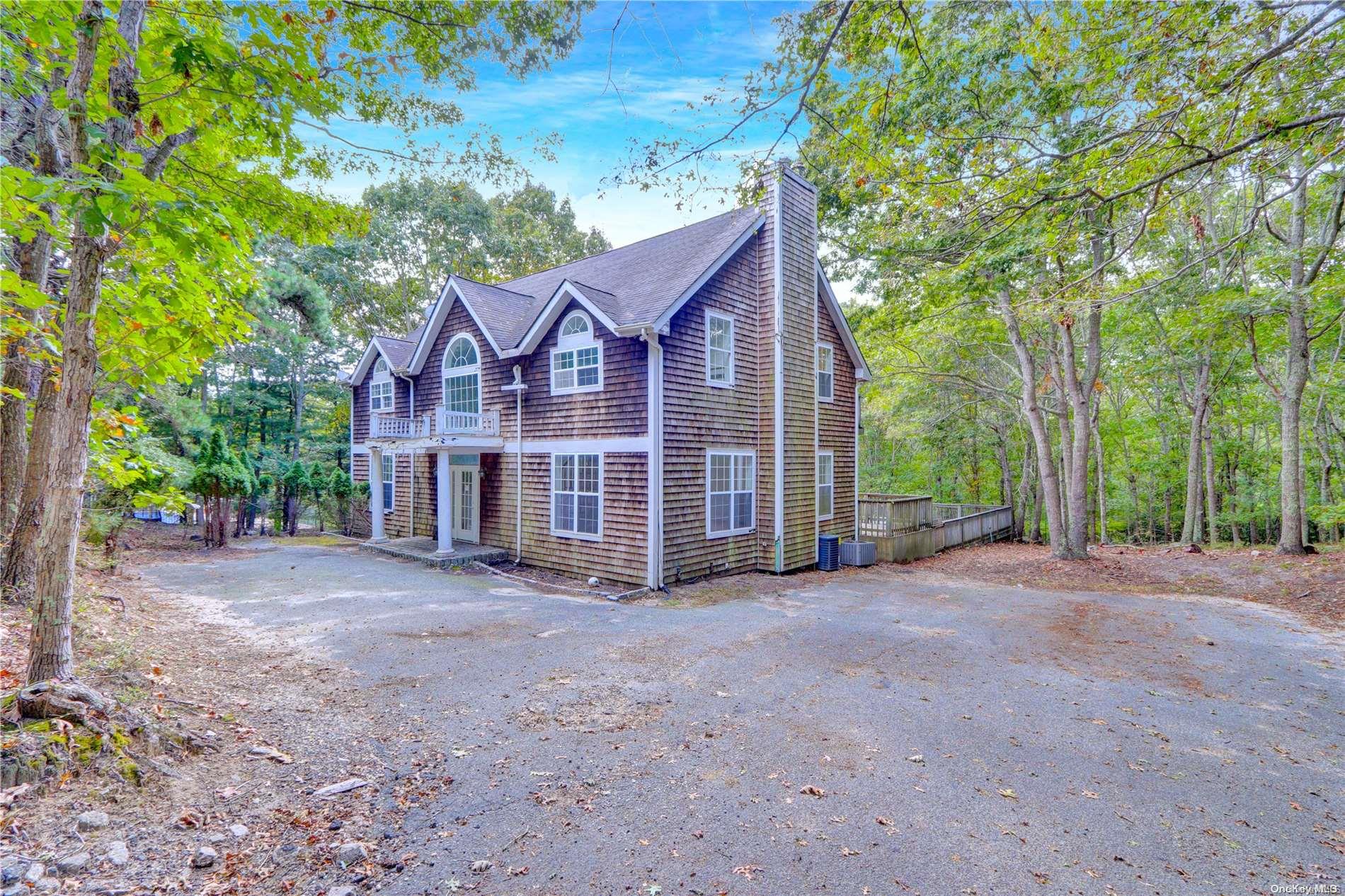 a view of a house with a yard and large trees