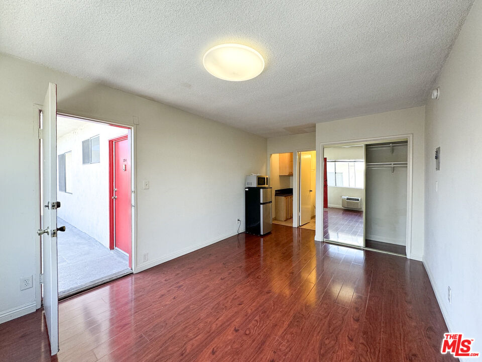 a view of empty room with wooden floor