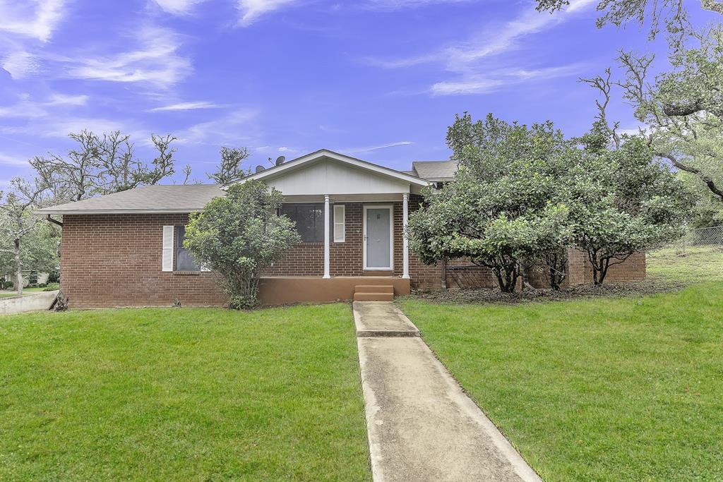 a front view of a house with a yard and trees