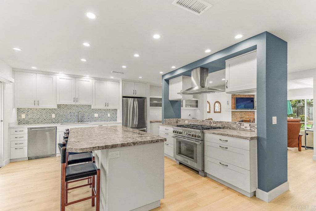 a kitchen with stainless steel appliances granite countertop a stove and a sink