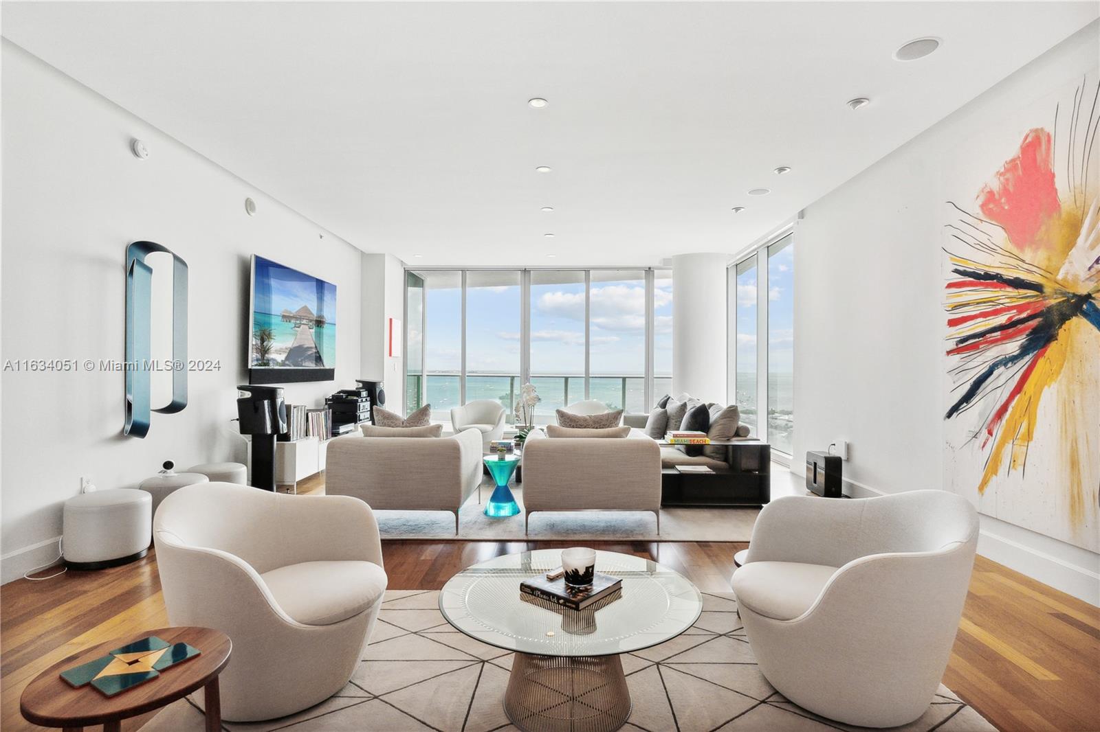 a living room with furniture kitchen view and a large window