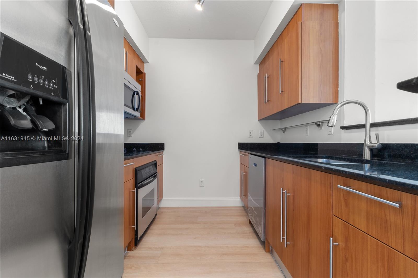 a kitchen with stainless steel appliances granite countertop a refrigerator and a sink