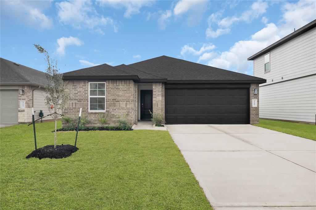 a front view of a house with a yard and garage