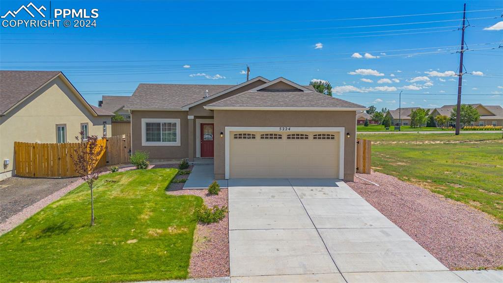 Ranch-style house with a garage and a front yard