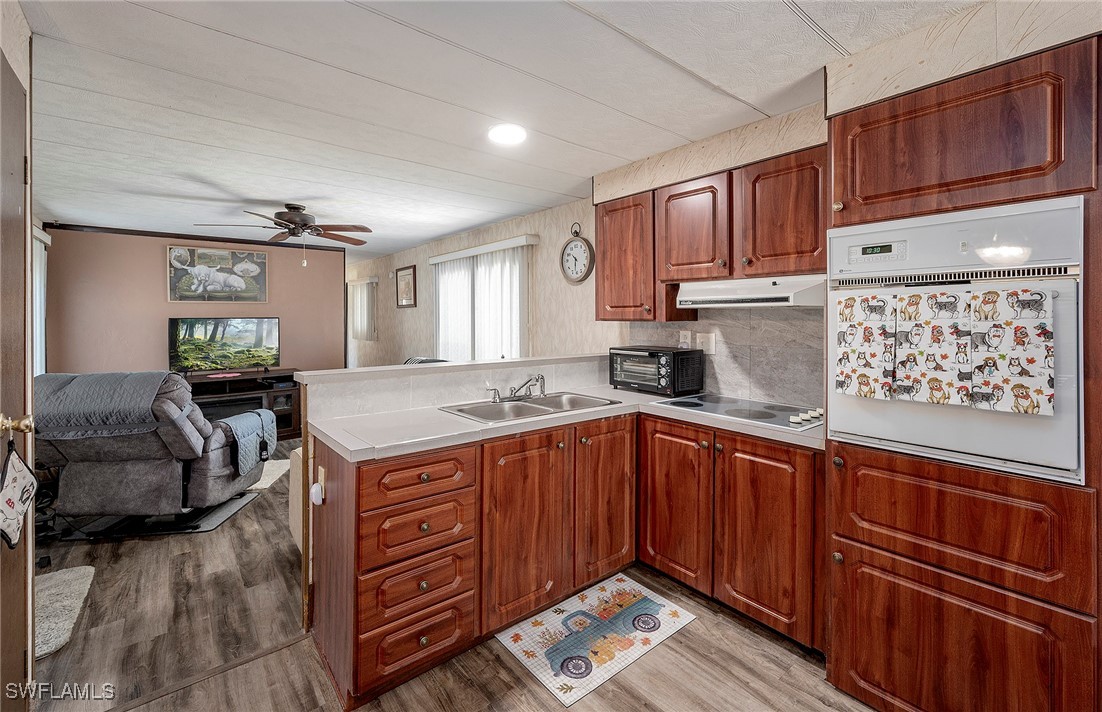 a kitchen with stainless steel appliances granite countertop a sink dishwasher stove and wooden cabinets