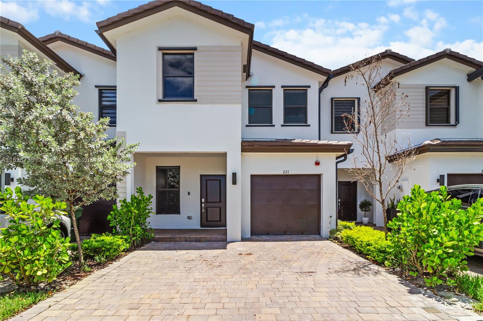 a front view of a house with yard and parking