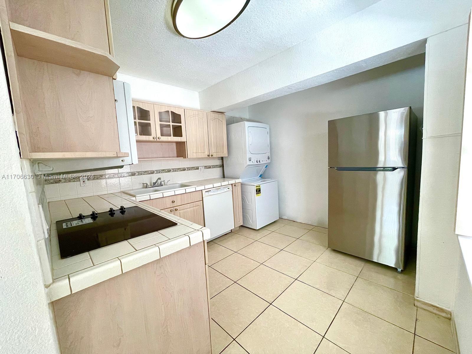 a kitchen with a sink a refrigerator and cabinets