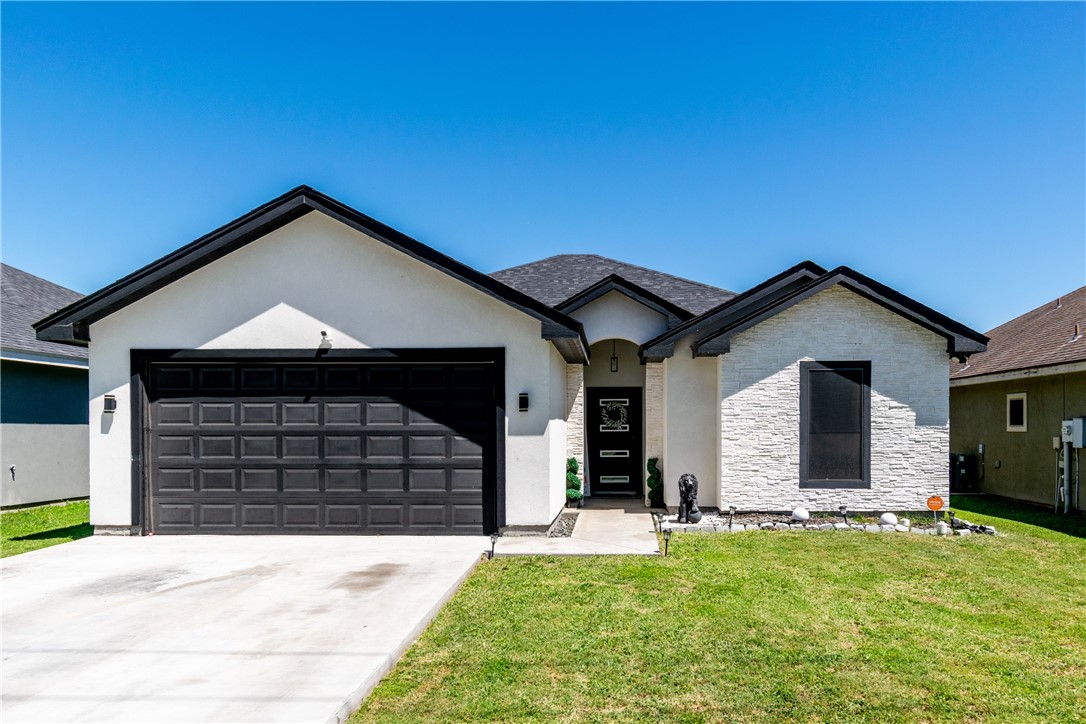 a front view of a house with a yard and garage