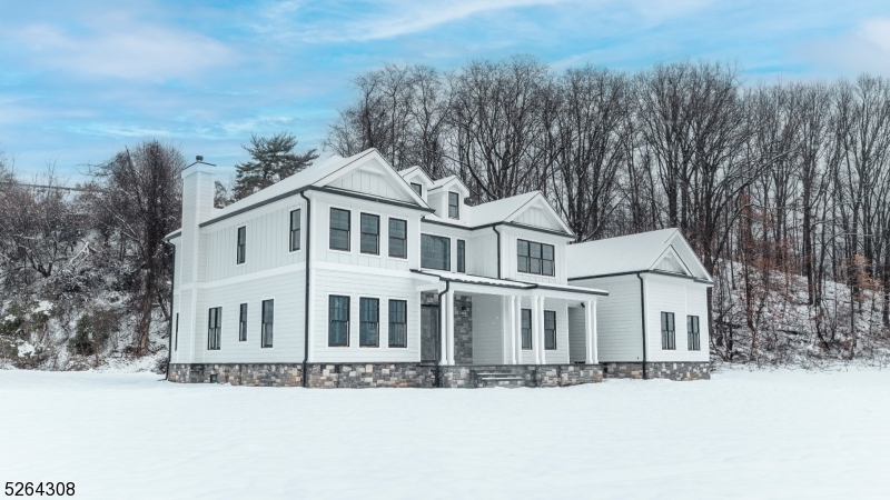 a front view of a house with a yard covered with snow in middle