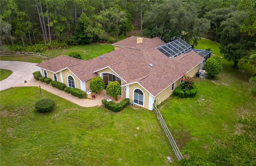 an aerial view of a house with swimming pool and garden