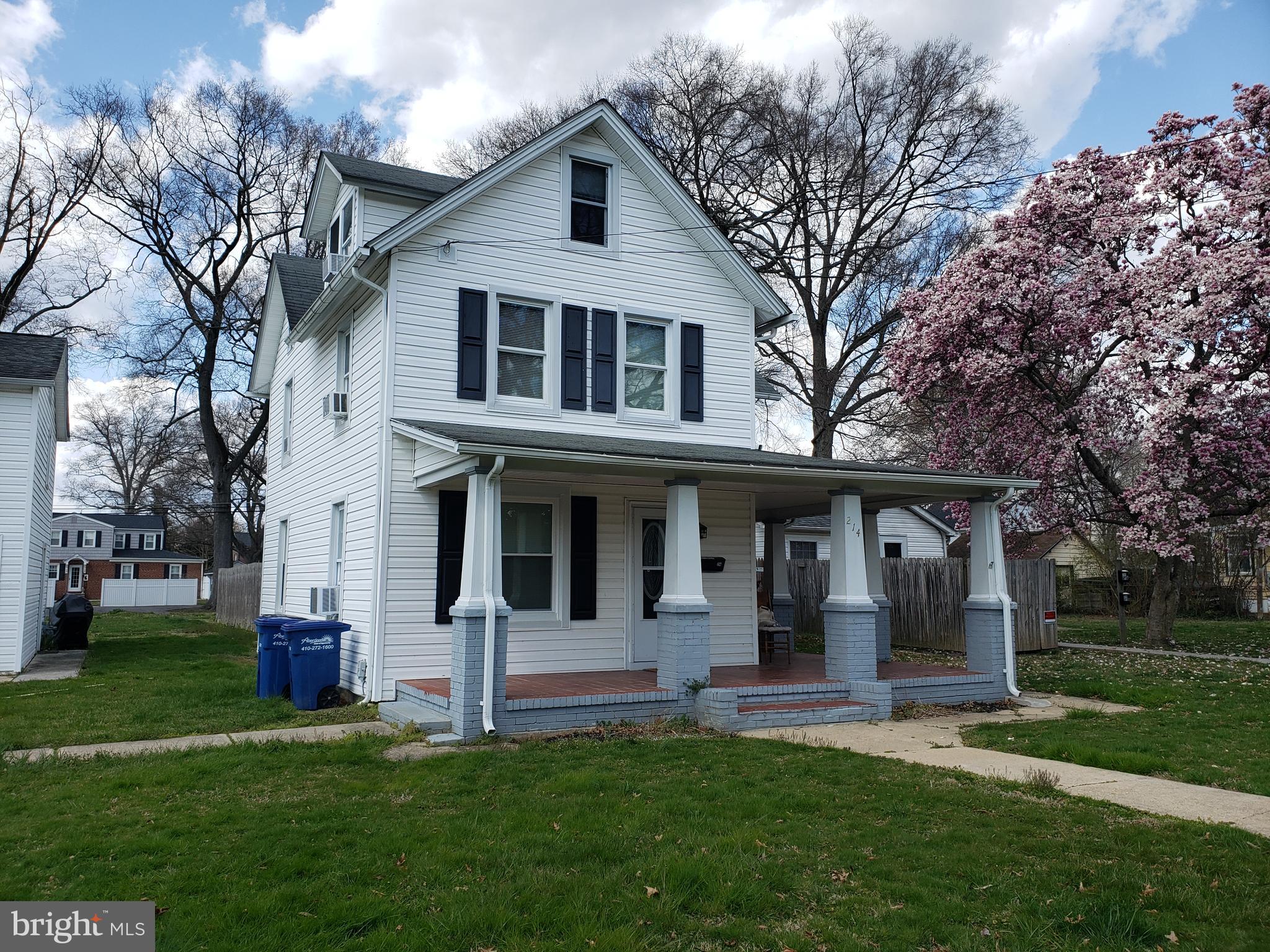 a view of a white house with a big yard and large tree