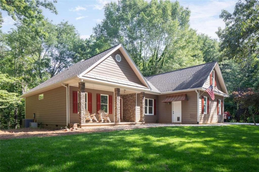 a view of a house with a yard and porch