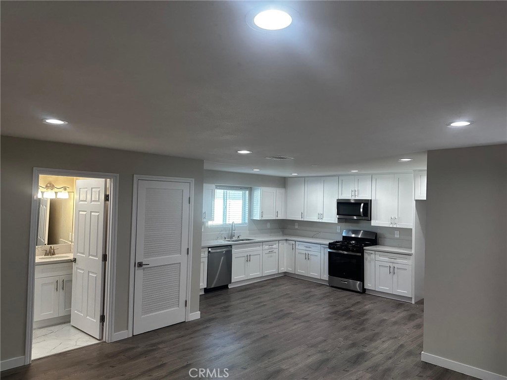 a kitchen with stainless steel appliances granite countertop a refrigerator and a stove top oven