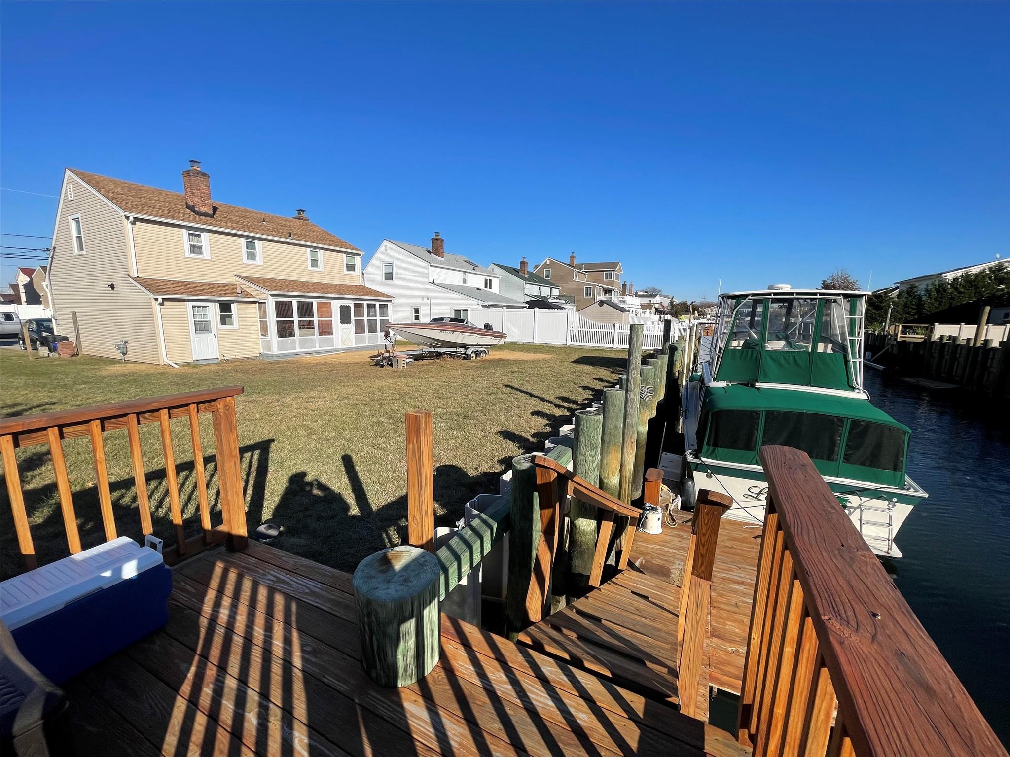 Dock area with a water view and a lawn