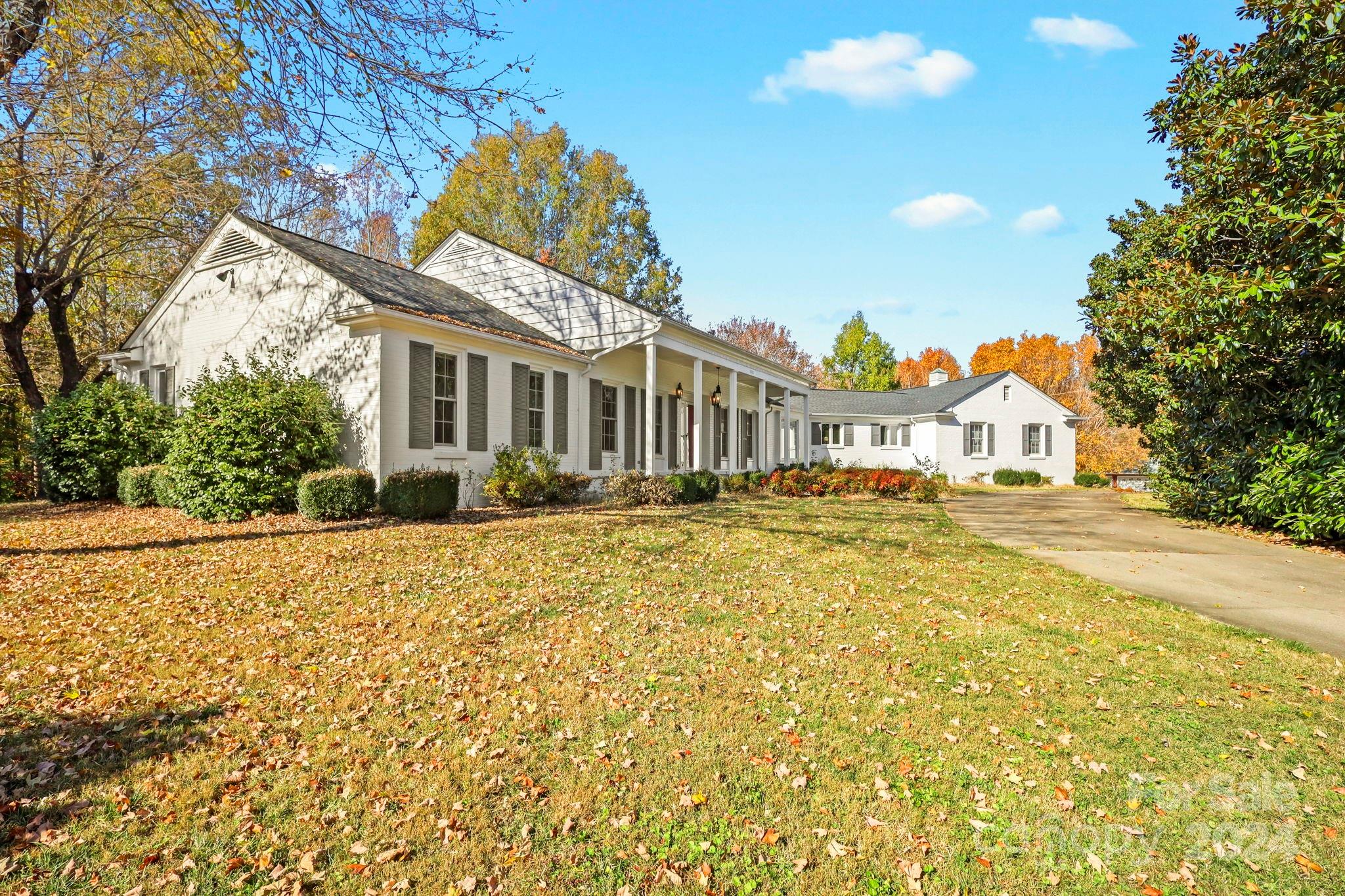 a front view of a house with a yard and potted plants