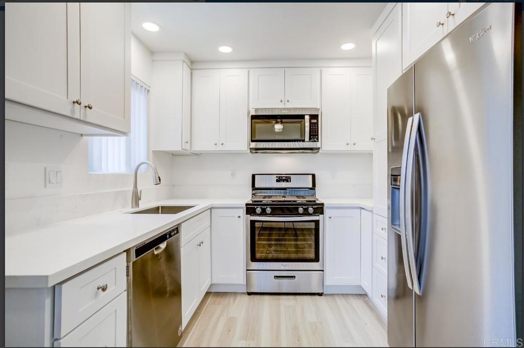 a kitchen with stainless steel appliances a stove a sink and a refrigerator