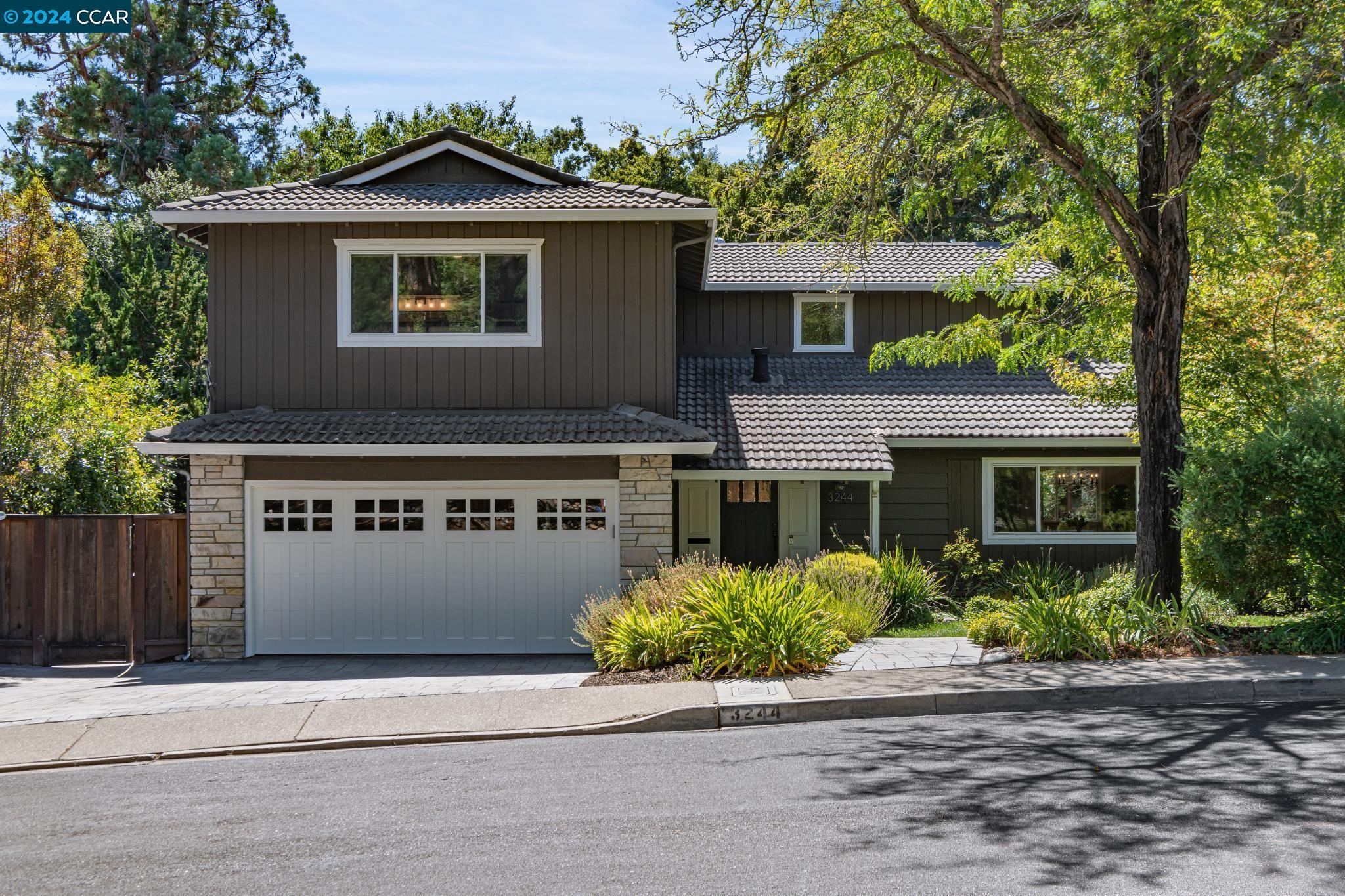 a front view of a house with a yard and a garage