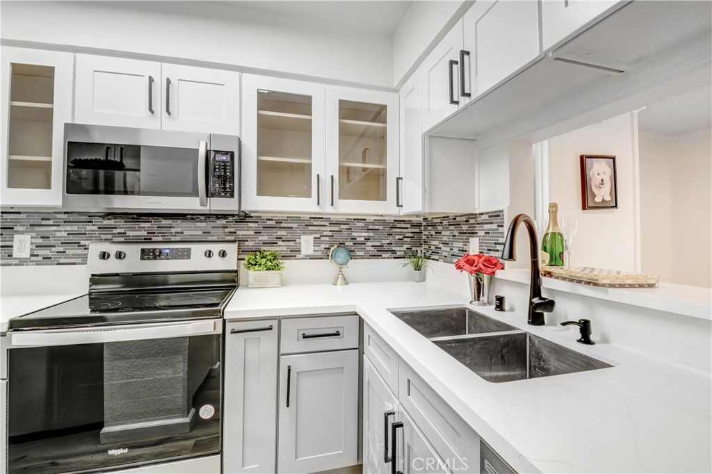 a kitchen with stainless steel appliances granite countertop a sink stove and cabinets