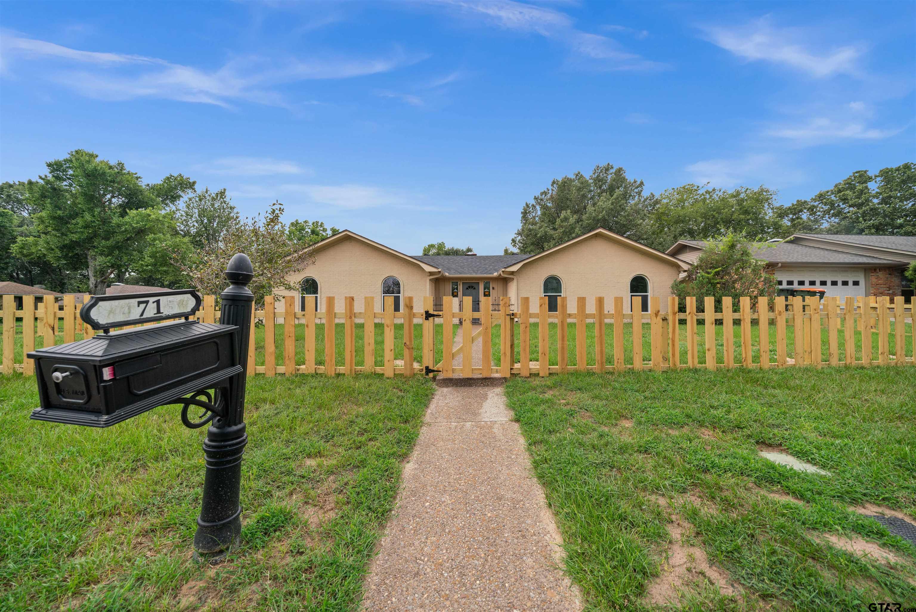 a view of a house with backyard and a garden