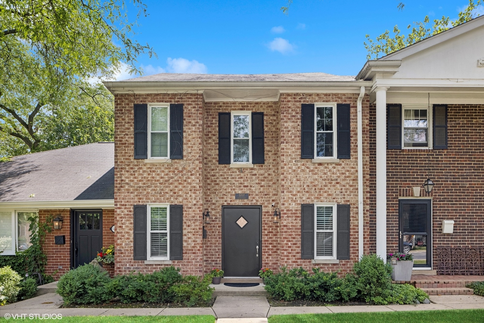 front view of a brick house with a small yard