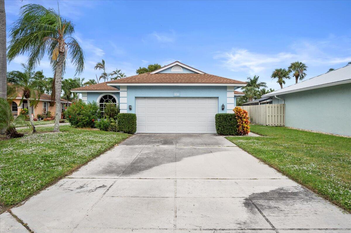 a front view of a house with a garden and a garage