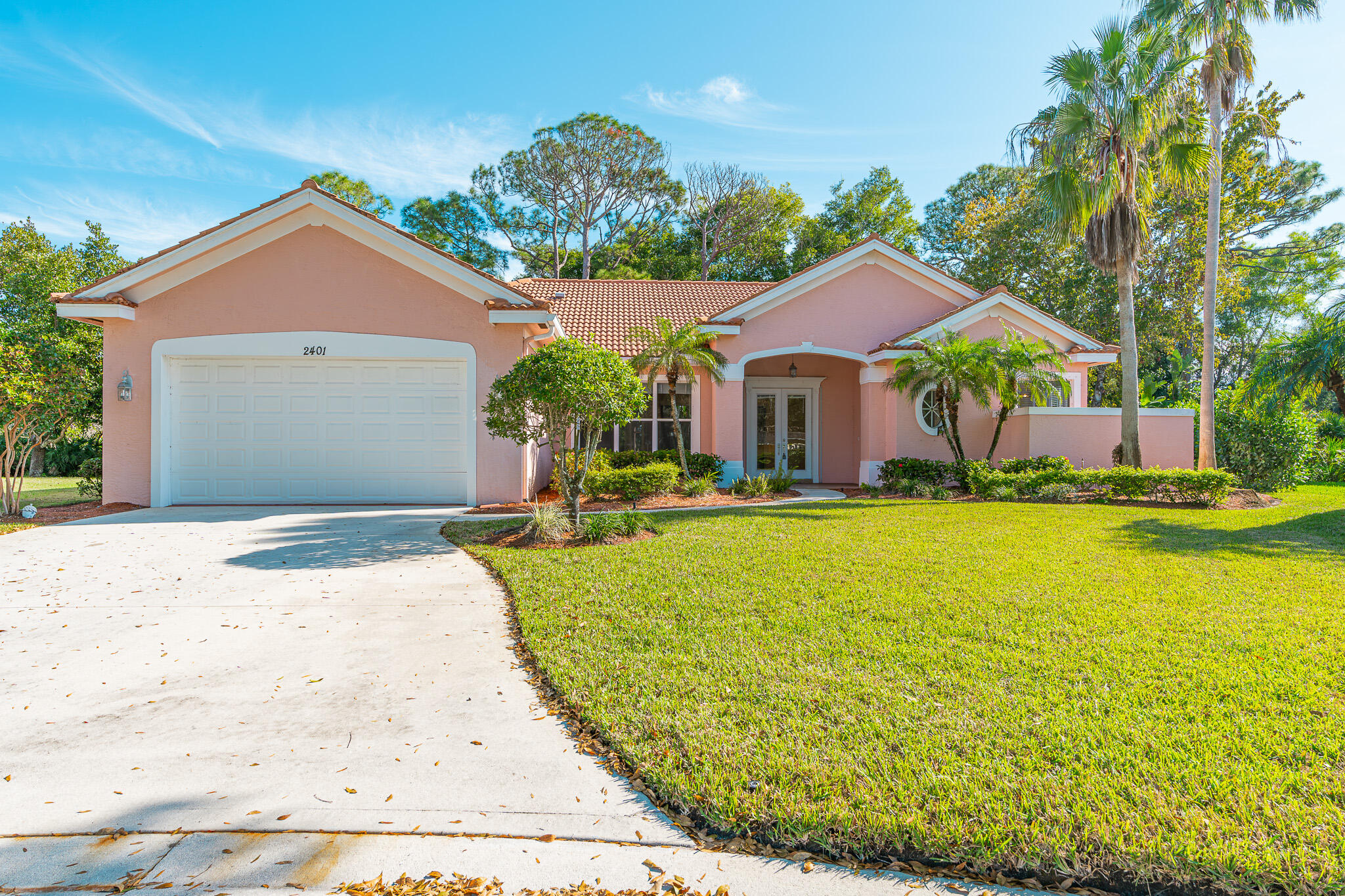 a front view of house with yard and trees in the background