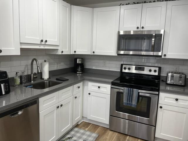 a kitchen with stainless steel appliances granite countertop a sink and a stove