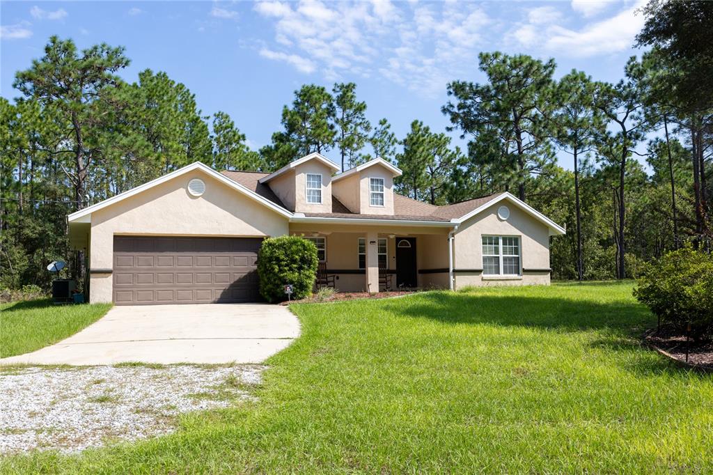 a front view of a house with yard and green space