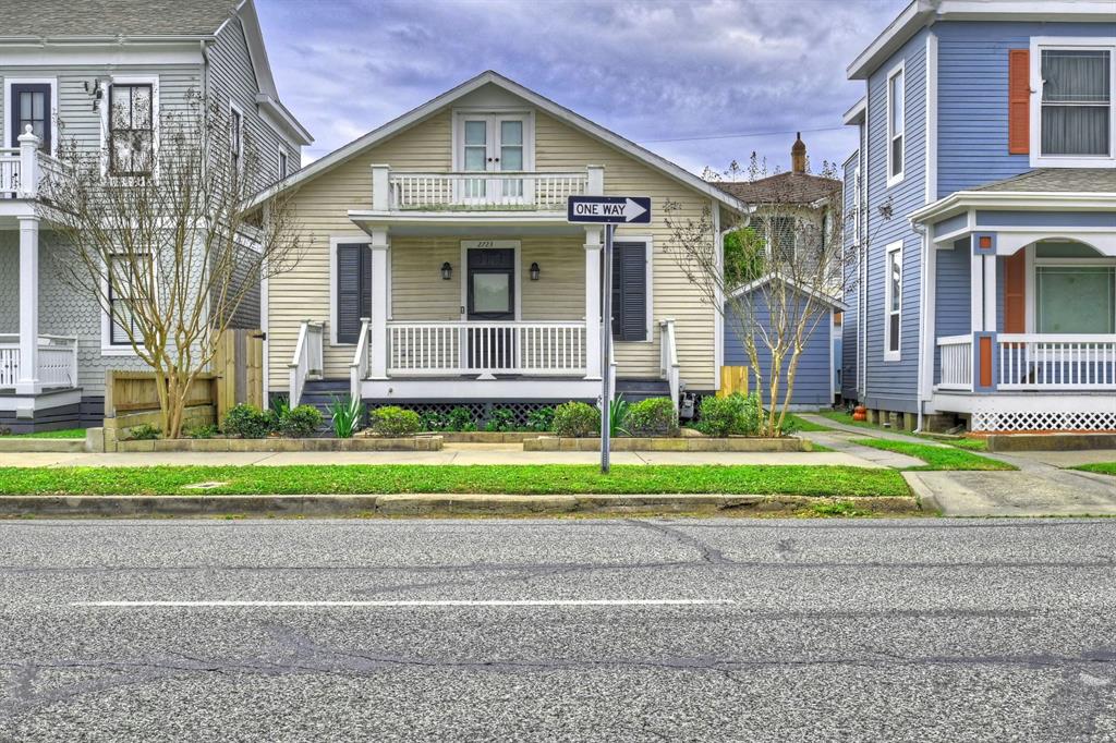 a view of a house with a yard and table and chairs next to a yard