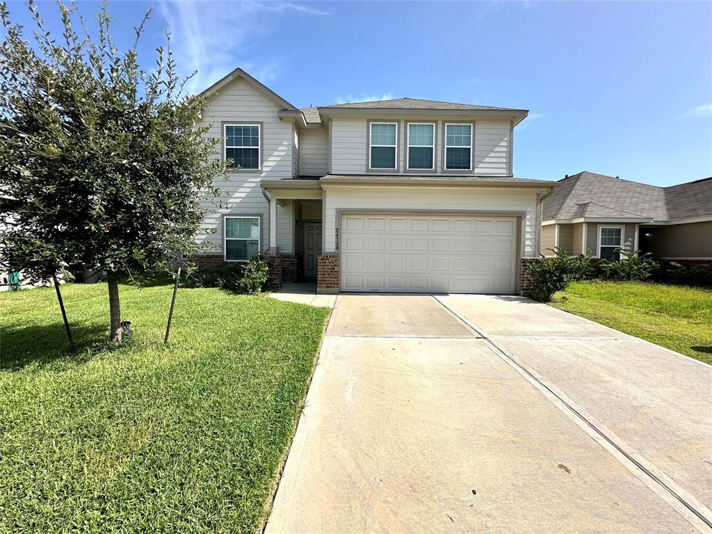 a front view of a house with a yard and garage