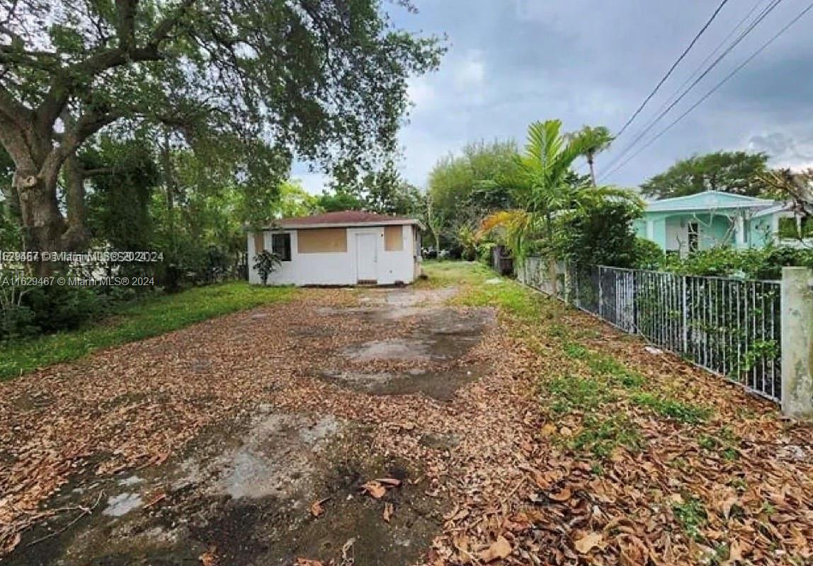 a view of a house with a yard and potted plants