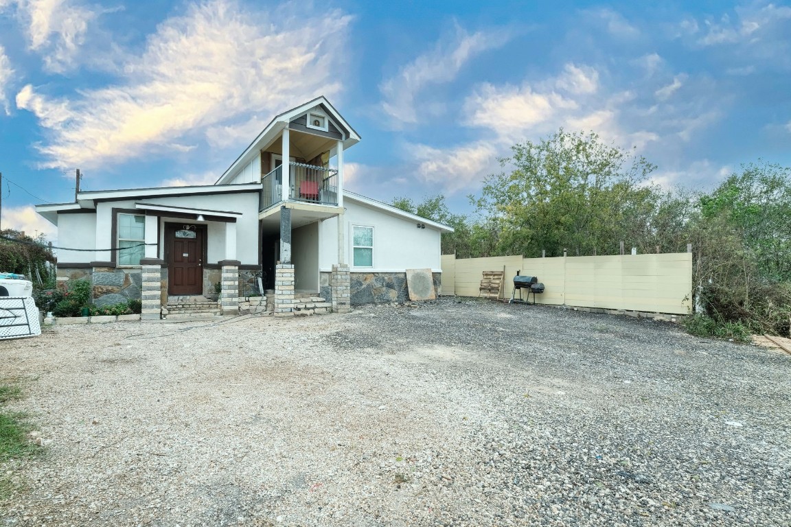 a front view of house with yard and trees in the background