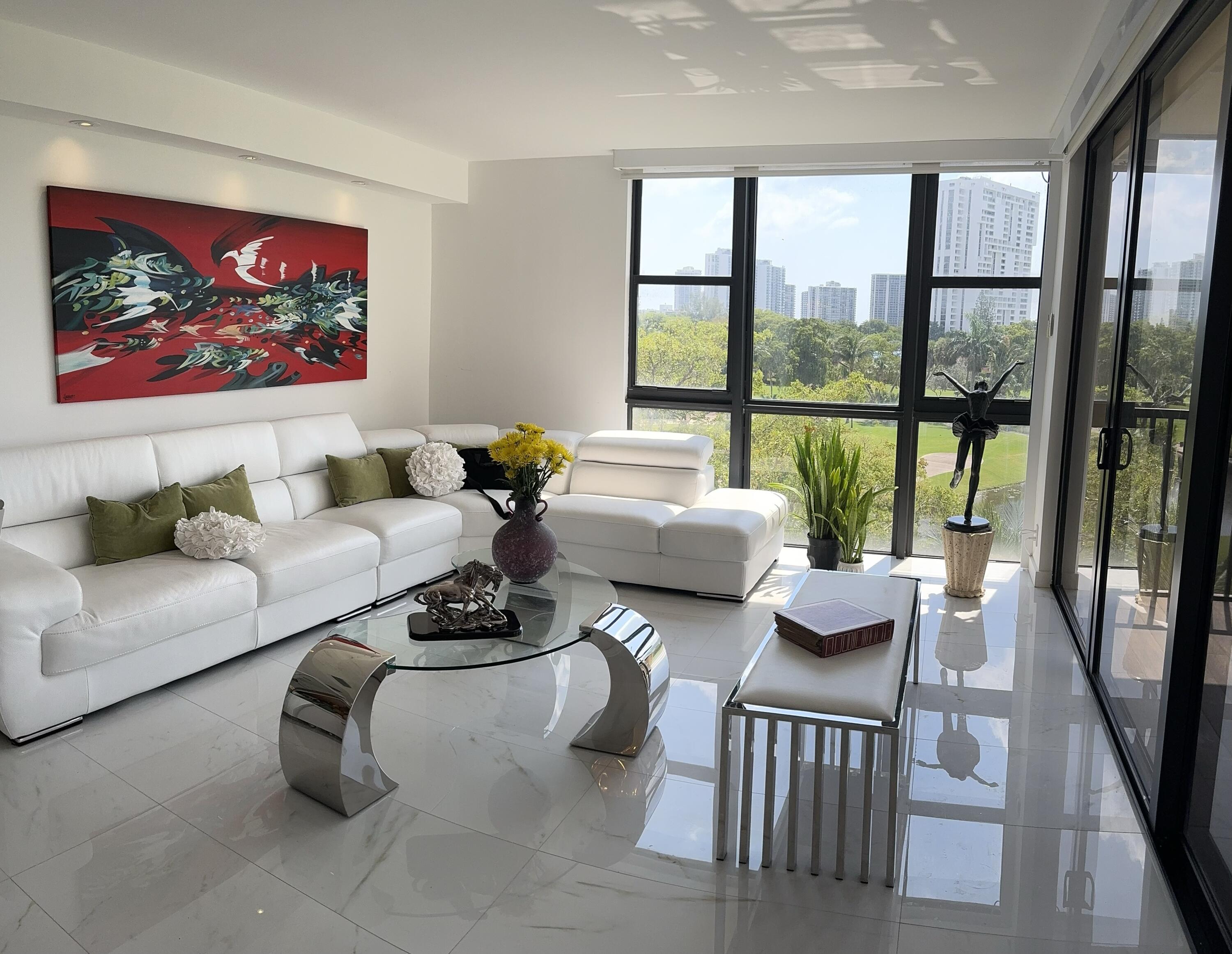 a living room with furniture and a floor to ceiling window